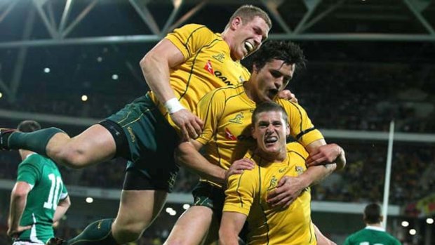 Wallaby Luke Burgess (right) celebrates his first Test try against Ireland.