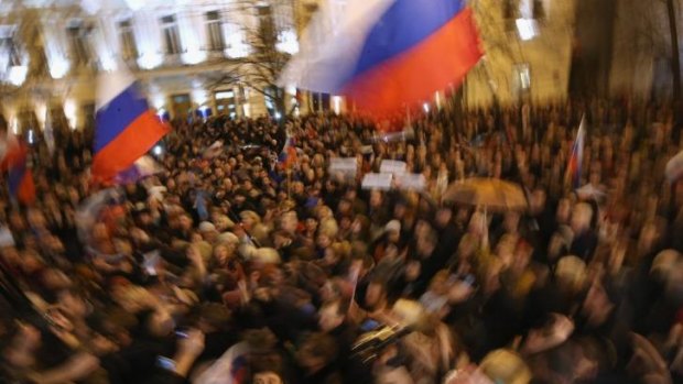 People waving Russian flags cheer following the confirmation by the Sevastopol regional council to support the vote for Crimea to secede from Ukraine and join Russia.