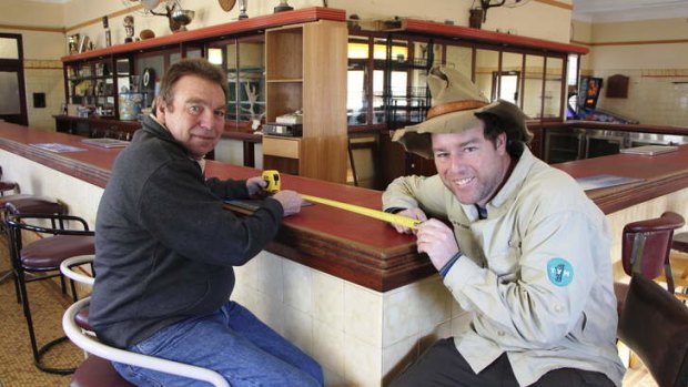 Publican Gary Green helps Tim measure the Long Bar at the Captains Flat Hotel.
