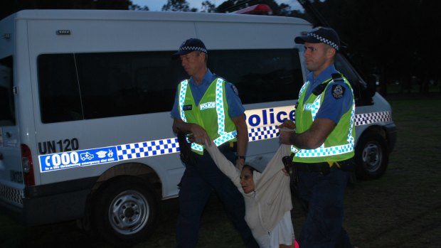 Police drag away and arrest protester Peta Garlett during the morning raid