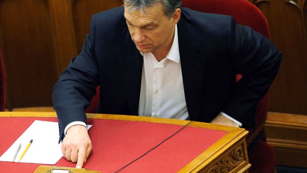 Hungarian Prime Minister Viktor Orban pushes the button to vote during a parliamentary session on March 11, 2013 in Budapest.