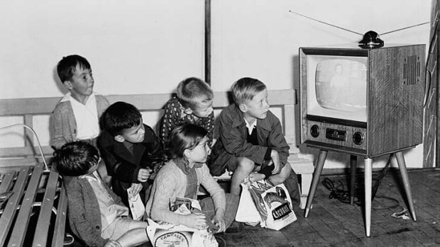 A group of children watch a television set on display at the Royal Easter Show