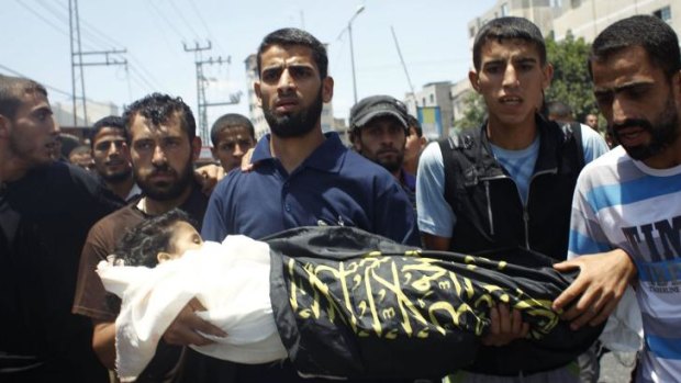 Palestinian mourners carry the body of four-year-old girl Sarah Sheik al-Eid after she was killed, along with her father and uncle, in a Israeli military strike the previous day.