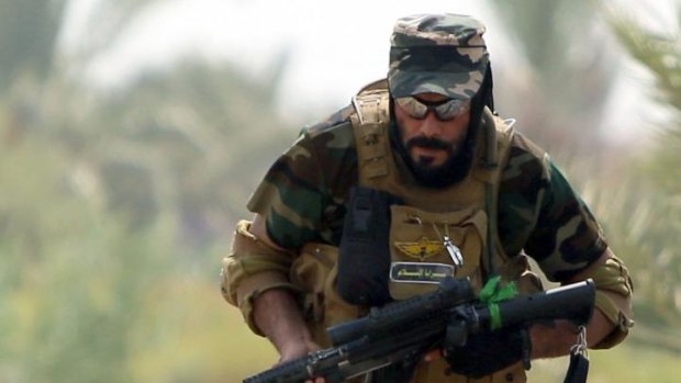 A Shiite Muslim fighter takes up a position against Islamic State fighters.
