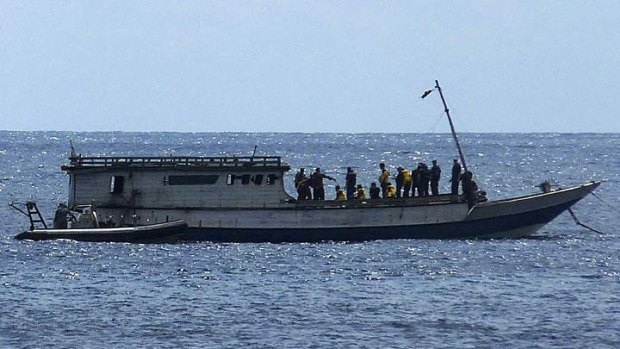 An Australian Navy boat comes alongside a boat carrying 50 asylum seekers after it arrived at Flying Fish Cove on Christmas Island on August 7.
