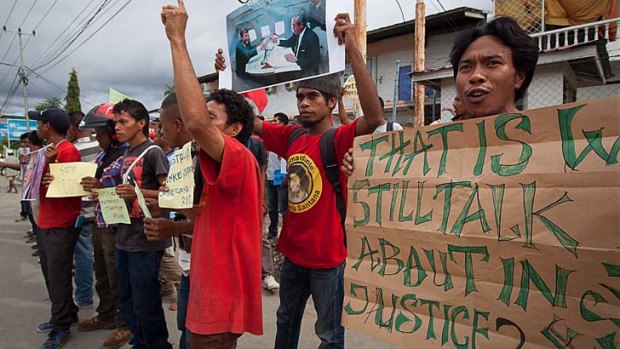Spying scandal: Protesters hold up signs during an anti-Australia rally in Dili, East Timor. The protests were in response to allegations government offices were bugged by Australian authorities.