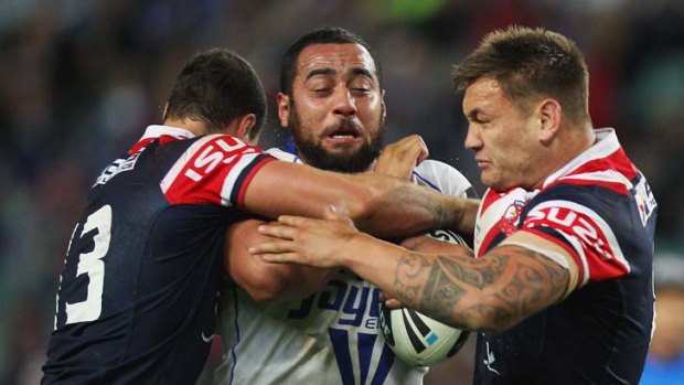 Crunch &#8230; two Roosters players tackle Sam Kasiano.