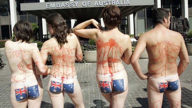 Demonstrators with the Australian flag painted on their buttocks and fake blood on other parts of their bodies stand in front of the Australian embassy in Washington during a small rally by People for the Ethical Treatment of Animals (PETA).