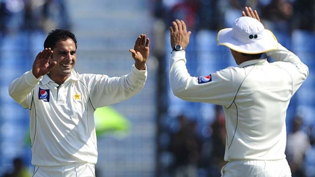 Pakistani bowler Abdur Rehman (L) in happier times, celebrating a Test wicket in 2011.