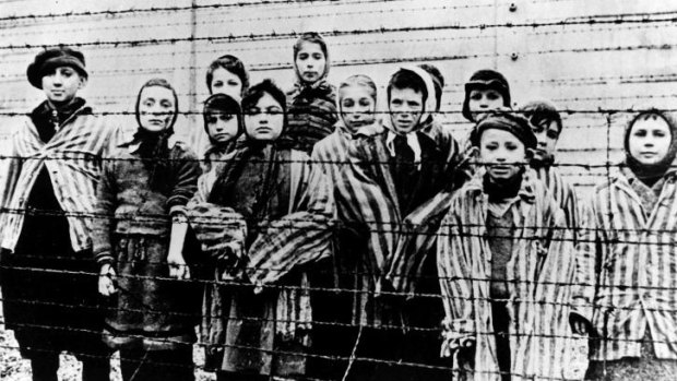 Children behind a barbed wire fence at the Nazi concentration camp at Auschwitz in southern Poland