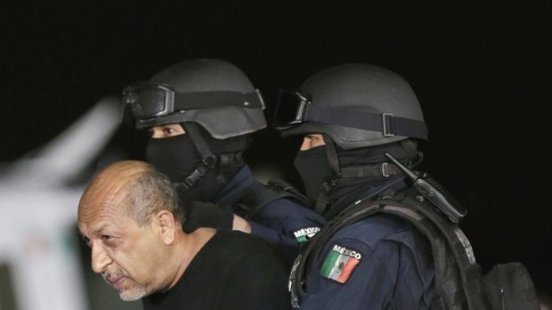 Mexico's most-wanted drug lord Servando "La Tuta" Gomez is escorted by police officers during a media conference about his arrest in Mexico City in February. 