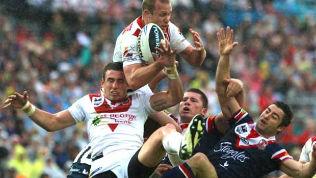 Flying Dragon  . . . Ben Hornby rises highest to gather a bomb as Darius Boyd and Mark Minichiello are sent tumbling.