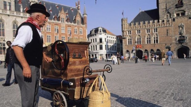 Pipeline to reduce Traffic on Bruges cobblestoned alleys: A man plays a barrel organ in Bruges' market square. 