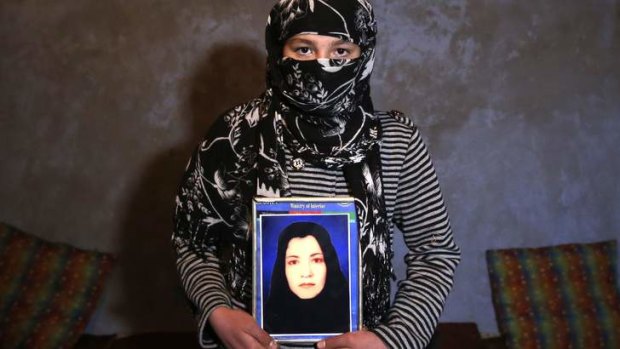 The daughter of Narges Rezaeimomenabad holds a picture of her mother.