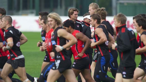 In the mix: The undefeated Bombers training under the watchful eye of coach James Hird yesterday.