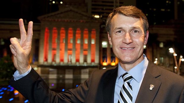 Graham Quirk shows a victory sign in front of Brisbane City Hall after announcing he had been re-elected as Brisbane Lord Mayor.