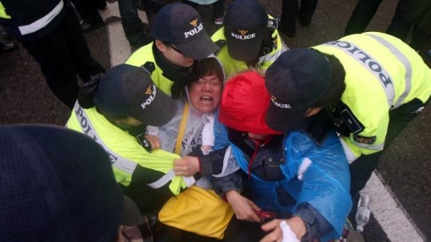 Relatives of missing passengers from the ferry Sewol react as they are blocked from marching by South Korean police on Sunday.