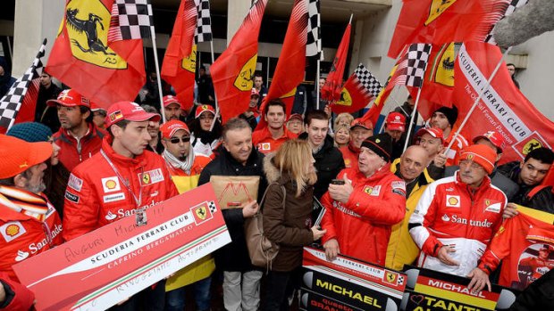 Fans of Michael Schumacher gather in front of the main entrance of Grenoble University Hospital Centre.