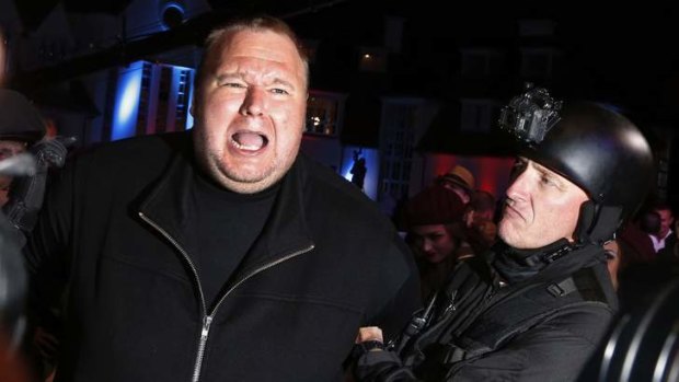 An actor in police costume mock-arrests Megaupload founder Kim Dotcom, left, as he launches his new file sharing site "Mega".