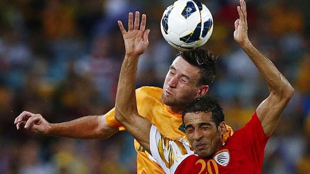 Can't bear to watch: Robert Cornthwaite towers over Amad Al-Hosni on Tuesday night.