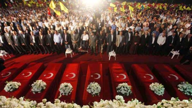 Rallying cry: Hezbollah supporters gather around mock coffins representing those who died on the Mavi Marmara, and a video image shows shrouded bodies on board.