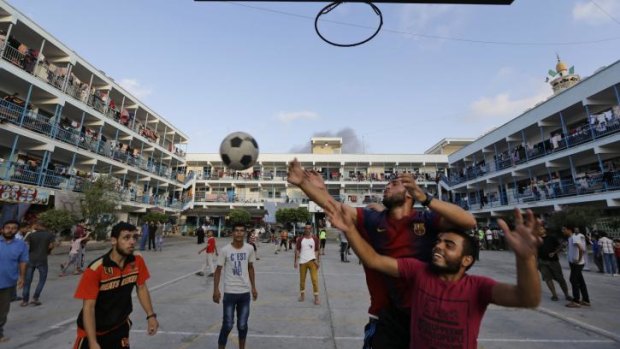 Displaced Palestinians play basketball in the courtyard of a UN school at Jebaliya refugee camp, in the northern Gaza Strip. The UN said rockets had been found at another such site.