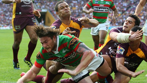 Chris McQueen of the Rabbitohs manages to burst through the Broncos' defence to score a try.