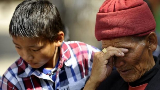 The father and son of a Sherpa killed in the avalanche wait for his body to arrive at the Sherpa Monastery.