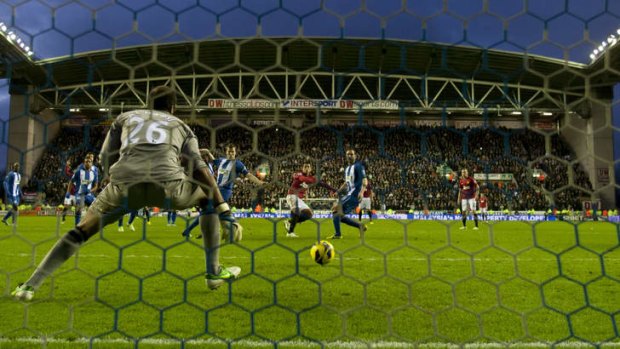 Javier Hernandez scores past Wigan's goalkeeper Ali Al-Habsi.