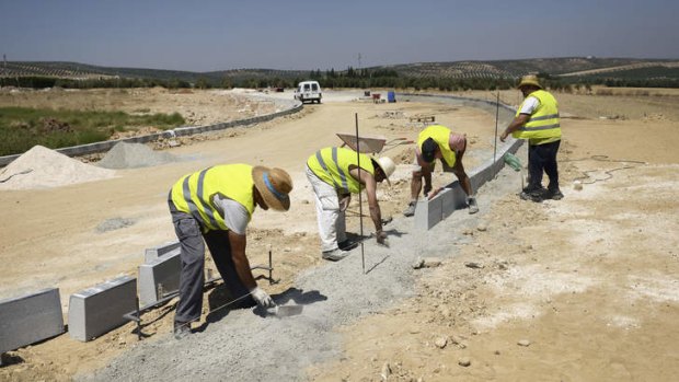 A group of municipal job-lottery winners work on the construction of an industrial park in Alameda, Spain.