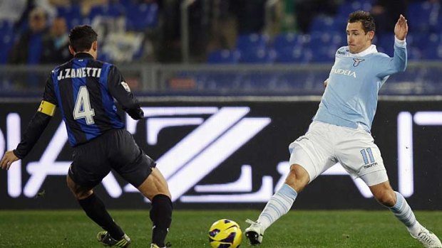 Lazio's Miroslav Klose (right) stretches to try and get to the ball before Javier Zanetti of Inter Milan.