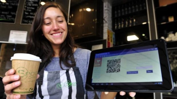 V Spot Cafe assistant manager Monica Furastec Danilevicz shows how the cafe accepts bitcoin payment.