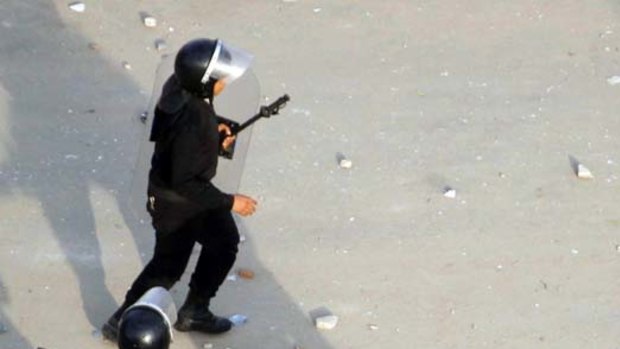 Police carry an injured colleague during clashes in Suez.