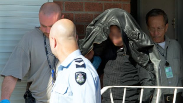Investigators lead a man from a house they raided in western suburban St Albans this morning. <i>Image digitally altered</i>