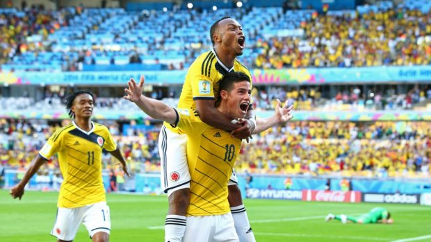 Growing belief ... James Rodriguez of Colombia (bottom) celebrates scoring his teams third goal with Juan Camilo Zuniga (top) during the Group C match against Greece.