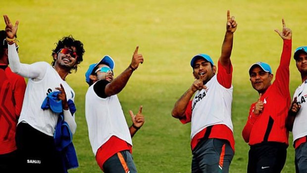 Indian players Shantakumaran Sreesanth, Virat Kohli, captain M.S. Dhoni, Virender Sehwag and Suresh Raina celebrate after winning a friendly warm-up soccer match against other team members during a training session.