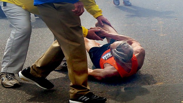 Mr Iffrig is helped from the ground before he staggers across the finish line.