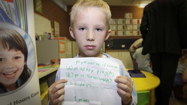 Advice: Cameron, 7, with the prime ministerial to-do list he thoughtfully compiled before Julia Gillard's visit to his holiday daycare program at a Canberra school.