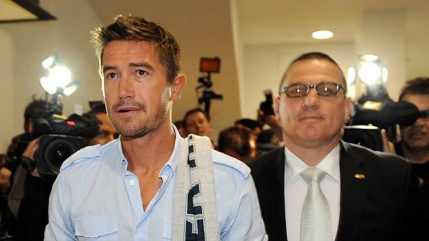 Harry Kewell walks through Melbourne Airport this morning.