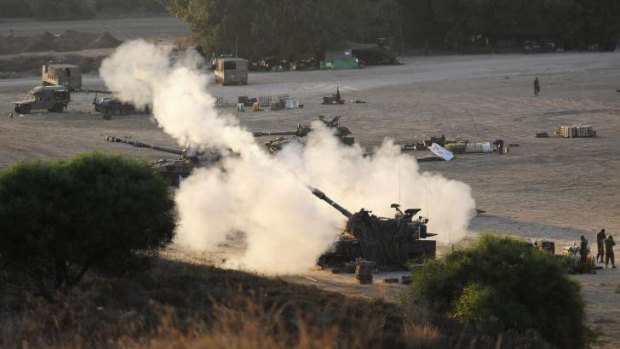 An Israeli tank fires a 155mm shell towards targets in the Gaza Strip on Tuesday. Dozens of Israeli reservists have refused to fight in Gaza.