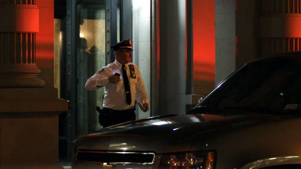 A police officer leaves the luxury Manhattan apartment building where the family lived.