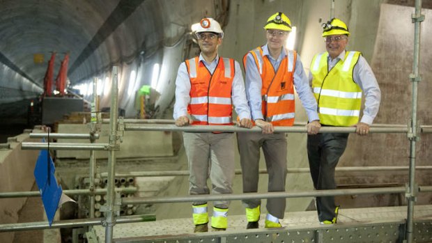 Brisbane Lord Mayor Graham Quirk, project director at Transcity Joint Venture Fernando Fajardo and Deputy Prime Minister Warren Truss pose for a photo in the unfinished Legacy way Tunnel in Brisbane.