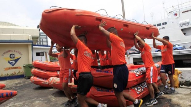 Members of the Philippine Coast Guard carry a rescue boat as they prepare for Typhoon Rammasun, locally name Glenda, in Manila.