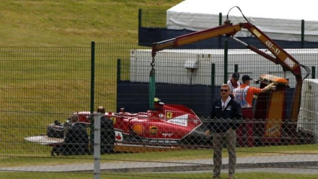 The car of Finland's Kimi Raikkonen is lifted off the track following a crash.