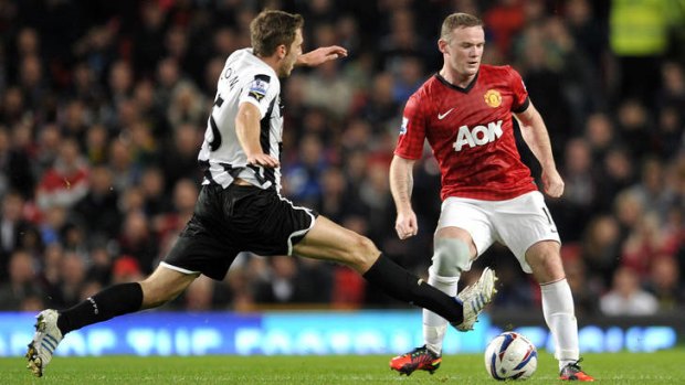Manchester United's Wayne Rooney, right, is tackled by Newcastle's United's  Dan Gosling.