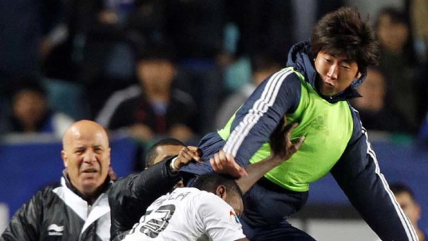 Take that ... a Suwon Bluewings player attacks Mohammed Kasola of Al-Sadd.