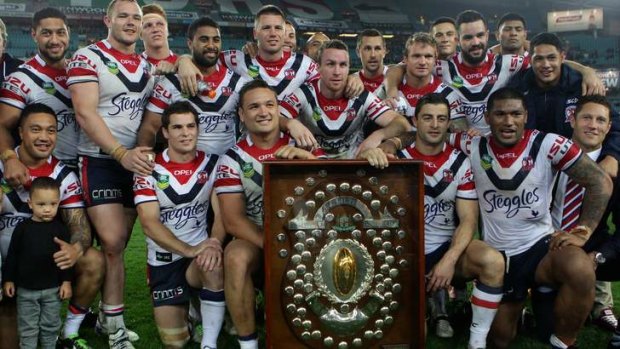 'I love the club': Anthony Minichiello, front row, third from right, and Roosters teammates with the J.J. Giltinan Shield after winning the minor premiership on Friday night.