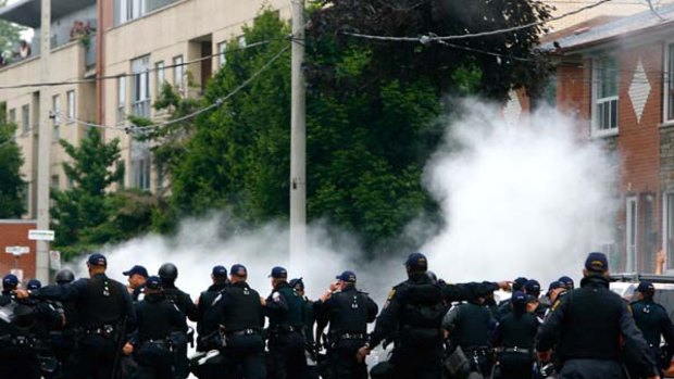 Police use smoke bombs to disperse protestors at a rally outside the temporary G20 police detention centre.