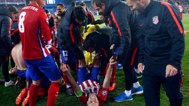 Atletico's Gab, on the ground, celebrates at the end of the Champions League second leg soccer match between Atletico Madrid and PSV Eindhoven at the Vicente Calderon stadium in Madrid.