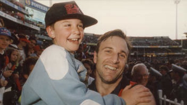 It’s in their genes: Tim Watson celebrates with son Jobe, then seven, after the 1993 grand final.